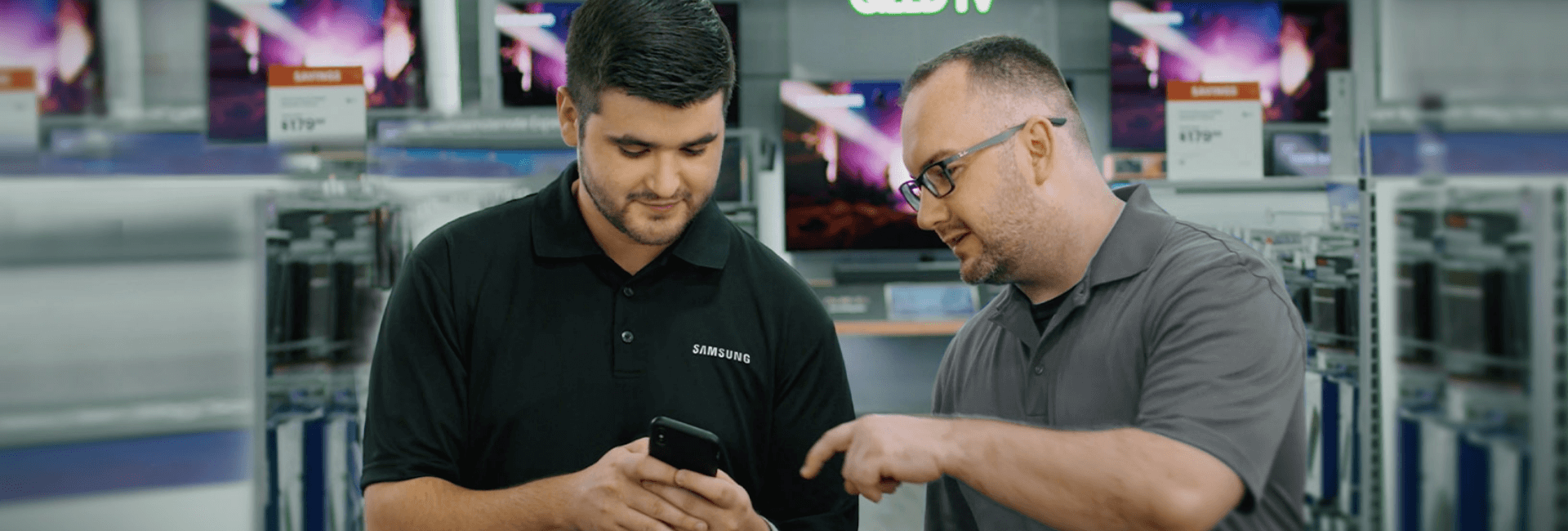 Two men looking at a phone talking